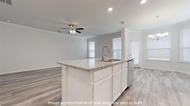 kitchen with a wealth of natural light, light hardwood / wood-style flooring, light stone counters, and a kitchen island with sink