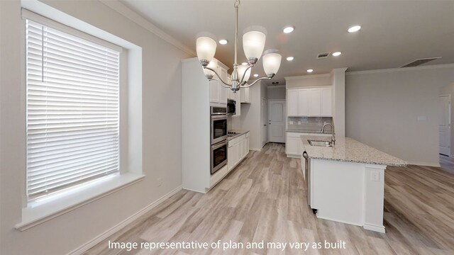 kitchen with light stone countertops, pendant lighting, ornamental molding, and a notable chandelier