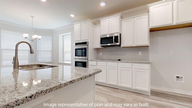 kitchen featuring pendant lighting, sink, appliances with stainless steel finishes, light hardwood / wood-style floors, and white cabinetry