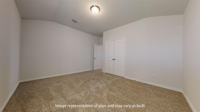 empty room with carpet floors and vaulted ceiling