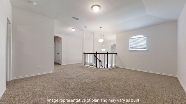 empty room with light colored carpet and vaulted ceiling