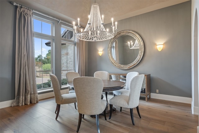 dining room featuring a notable chandelier, lofted ceiling, and light hardwood / wood-style flooring