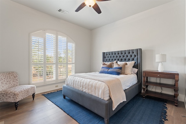 bedroom featuring wood-type flooring, multiple windows, and ceiling fan