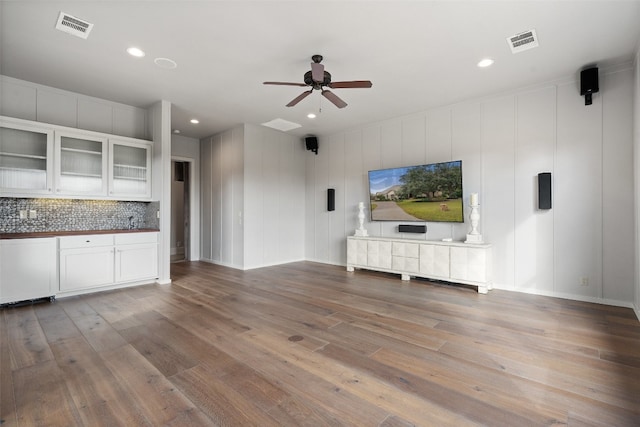 unfurnished living room with hardwood / wood-style flooring and ceiling fan