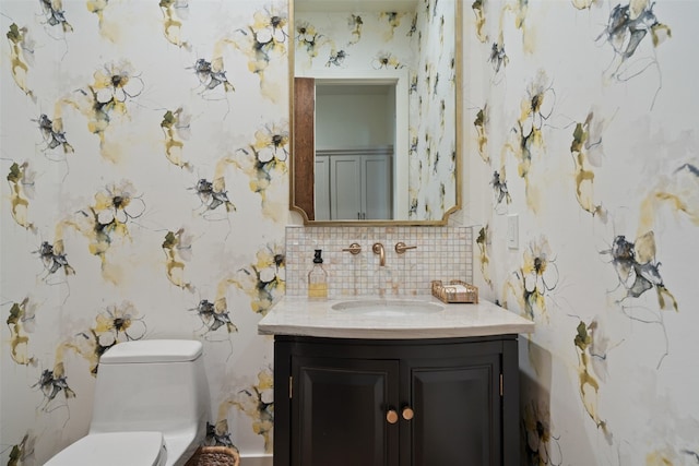 bathroom with decorative backsplash, toilet, and vanity