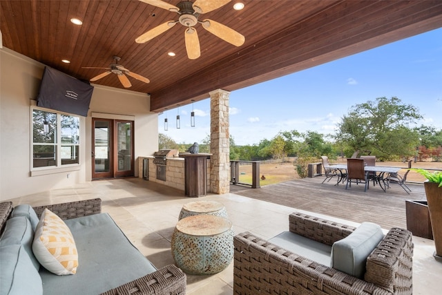 view of patio / terrace with an outdoor living space, ceiling fan, exterior kitchen, and a grill