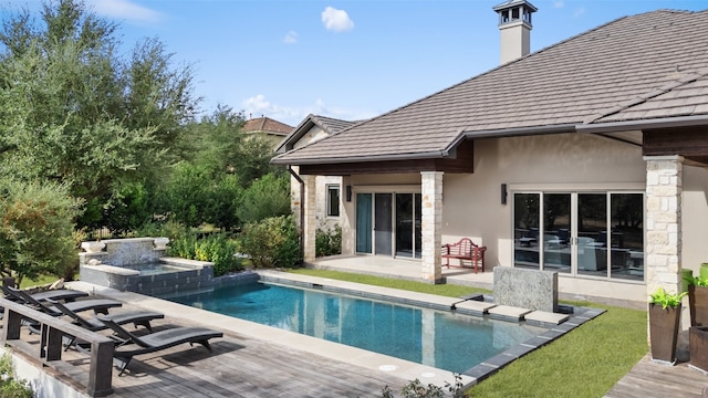 rear view of house featuring a swimming pool with hot tub and a patio area