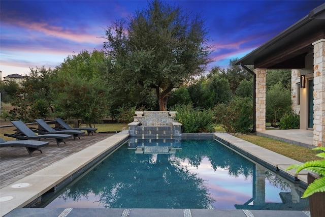 pool at dusk with a patio