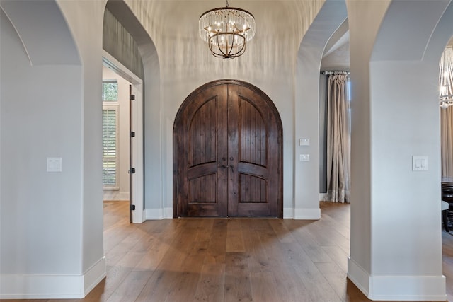 entrance foyer with hardwood / wood-style floors and a notable chandelier