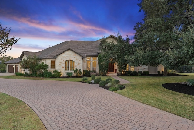 view of front of property featuring a lawn and a garage