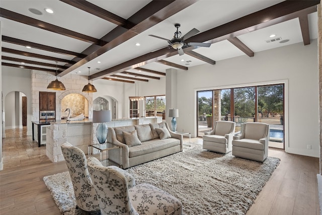 living room featuring ceiling fan, beam ceiling, light wood-type flooring, and wine cooler