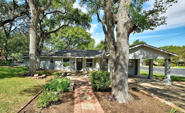 ranch-style home with a carport and a front lawn