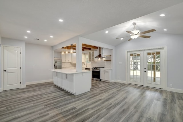 kitchen featuring french doors, light hardwood / wood-style flooring, vaulted ceiling, appliances with stainless steel finishes, and white cabinetry