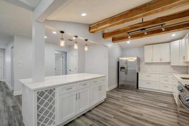 kitchen with white cabinets, appliances with stainless steel finishes, light hardwood / wood-style floors, and tasteful backsplash