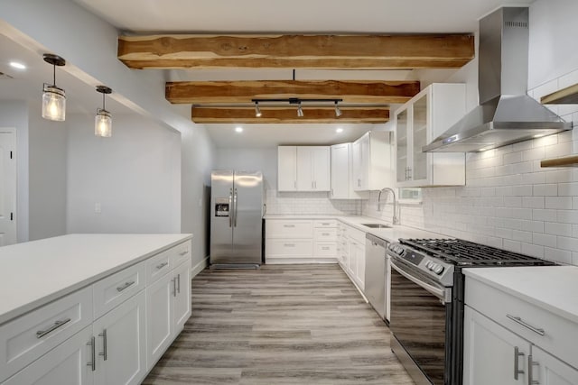 kitchen with white cabinets, wall chimney exhaust hood, tasteful backsplash, beamed ceiling, and stainless steel appliances