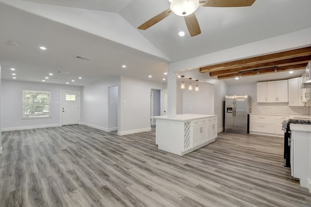 kitchen with white cabinets, lofted ceiling with beams, light wood-type flooring, and appliances with stainless steel finishes