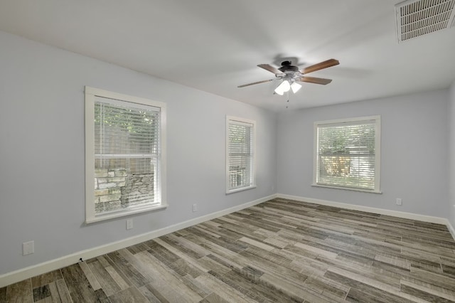 spare room with ceiling fan, light hardwood / wood-style floors, and a wealth of natural light