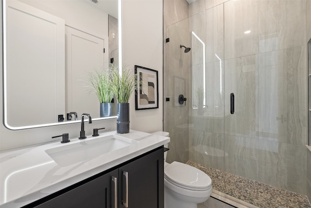 bathroom featuring an enclosed shower, vanity, and toilet