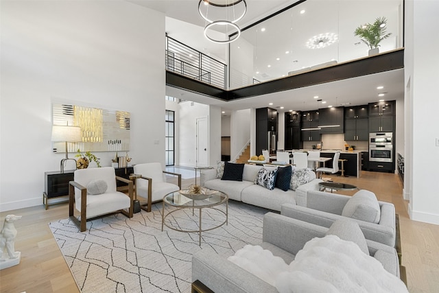 living room with a high ceiling and light hardwood / wood-style flooring