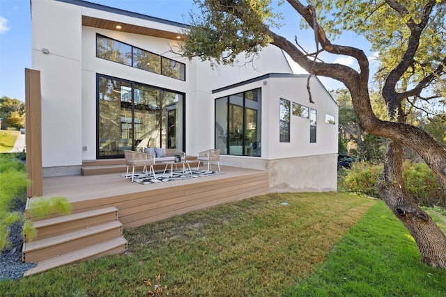 rear view of property featuring outdoor lounge area, a yard, and a deck