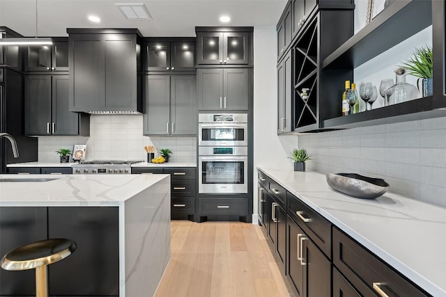 419 Hazeltine Dr, Lakeway, TX 78734 - kitchen with stainless steel appliances, backsplash, light stone countertops, recessed lighting, and glass insert cabinets