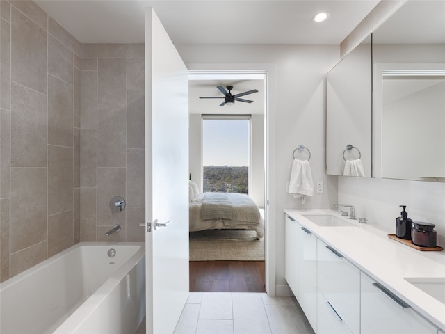 bathroom featuring tile patterned flooring, vanity, and tiled shower / bath