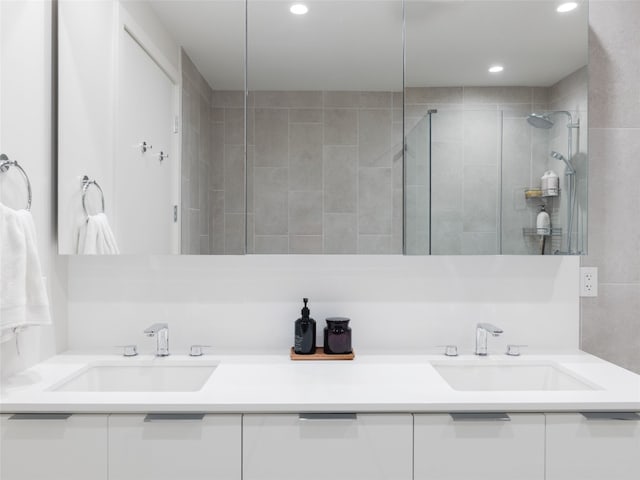 bathroom with a tile shower and vanity