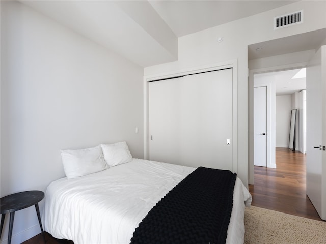 bedroom with wood-type flooring and a closet