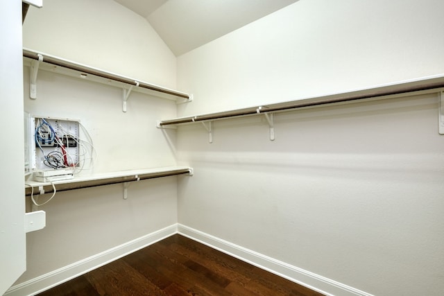 spacious closet featuring dark wood-type flooring and lofted ceiling