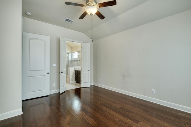 unfurnished bedroom featuring connected bathroom, ceiling fan, dark hardwood / wood-style flooring, and lofted ceiling