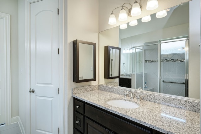 bathroom featuring vanity and a shower with shower door