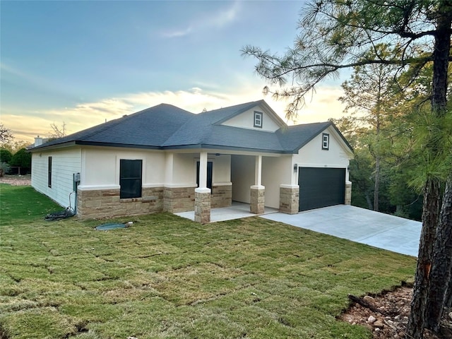 view of front of house with covered porch, a garage, and a lawn