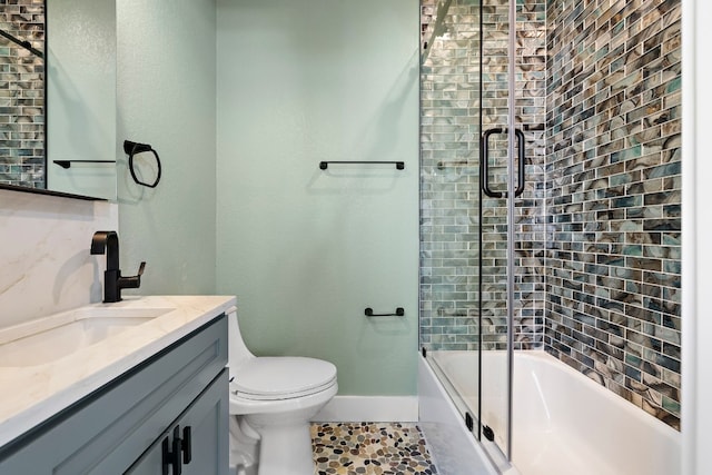 full bathroom with shower / bath combination with glass door, tile patterned floors, vanity, and toilet