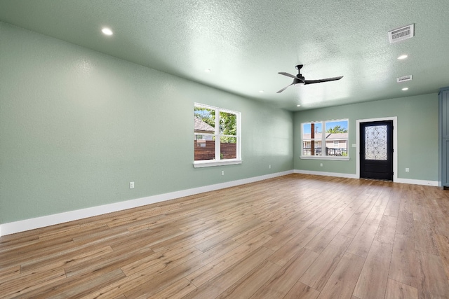 interior space with ceiling fan, light hardwood / wood-style floors, and a textured ceiling