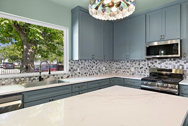 kitchen with appliances with stainless steel finishes, backsplash, light stone counters, and sink