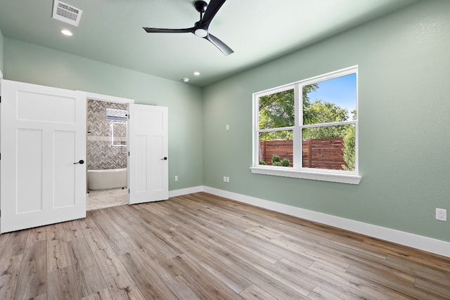 unfurnished bedroom featuring ceiling fan, ensuite bathroom, and light hardwood / wood-style floors