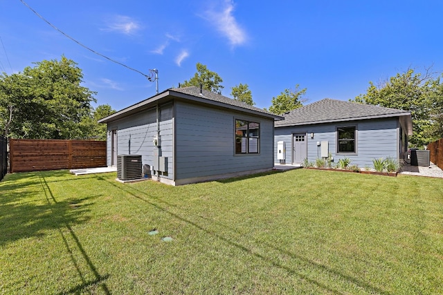 rear view of property featuring a yard and central AC unit