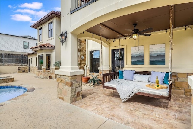 view of patio with ceiling fan and a balcony