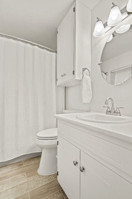 bathroom with vanity, wood-type flooring, and toilet