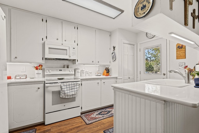 kitchen featuring sink, white appliances, decorative backsplash, white cabinets, and hardwood / wood-style flooring