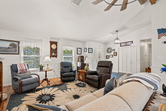 living room featuring ceiling fan, wood-type flooring, and vaulted ceiling