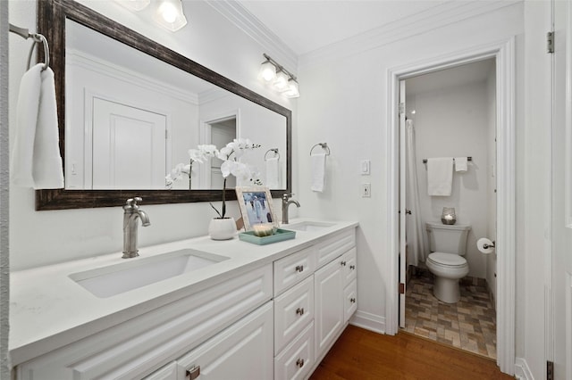 bathroom with toilet, vanity, ornamental molding, and hardwood / wood-style flooring