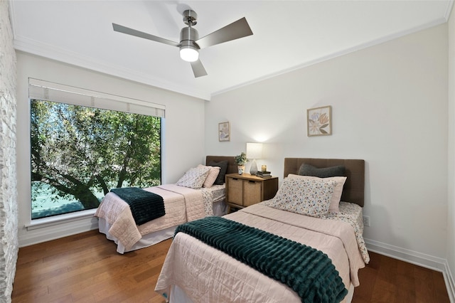 bedroom featuring ceiling fan, hardwood / wood-style flooring, and multiple windows