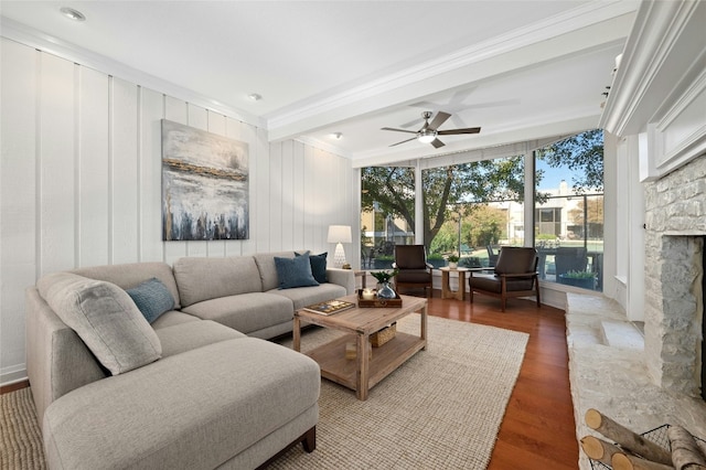 living room with ceiling fan, a fireplace, hardwood / wood-style floors, expansive windows, and ornamental molding