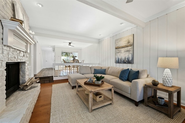 living room with a fireplace, beam ceiling, light hardwood / wood-style flooring, and ceiling fan