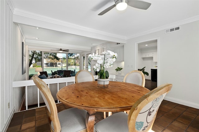 tiled dining space with ceiling fan and ornamental molding