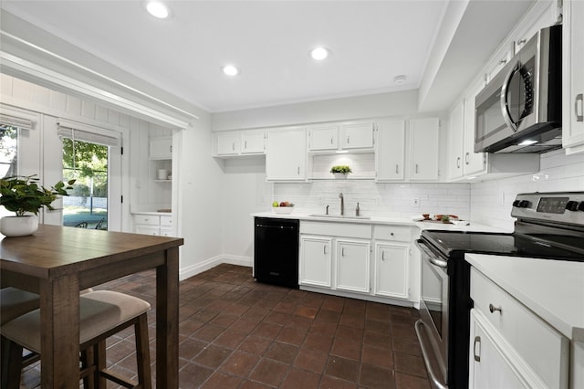 kitchen with dark tile patterned flooring, sink, stainless steel appliances, and white cabinetry