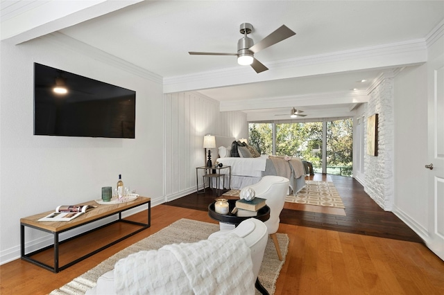 living room featuring ceiling fan, beam ceiling, ornamental molding, and hardwood / wood-style flooring