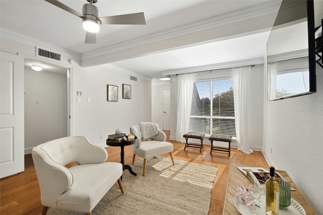 living area featuring ceiling fan, ornamental molding, and hardwood / wood-style flooring