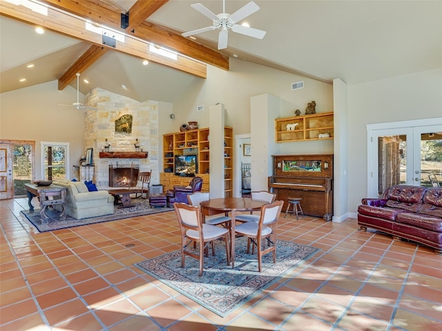 dining room with french doors, a stone fireplace, tile patterned flooring, high vaulted ceiling, and beamed ceiling